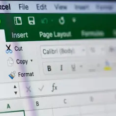 Ekran Excela z widocznym menu "Home" i opcjami "Cut", "Copy", "Paste". Dowiedz się, jak zablokować pierwszy wiersz w Excelu.