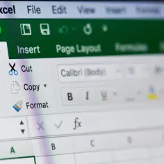 Ekran Excela z widocznym paskiem narzędzi, gdzie można zobaczyć opcje takie jak "Home", "Insert", "Page Layout" i "Formuły". To miejsce, gdzie uczysz się, jak tworzyć formuły w Excelu.