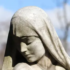 Kamienna rzeźba kobiety z zasłoniętą głową, smutna twarz. Może symbolizować tragiczną historię rodu Labdakidów.