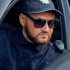 Policjant w okularach przeciwsłonecznych i czapce, gotowy do akcji. Marzysz, jak zostać policjantem kryminalnym?